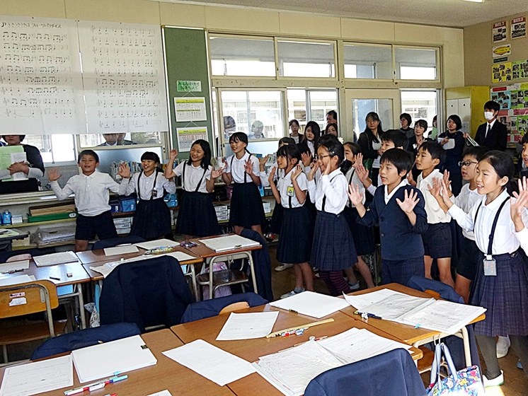 写真：立って手を上げて踊っている小学生